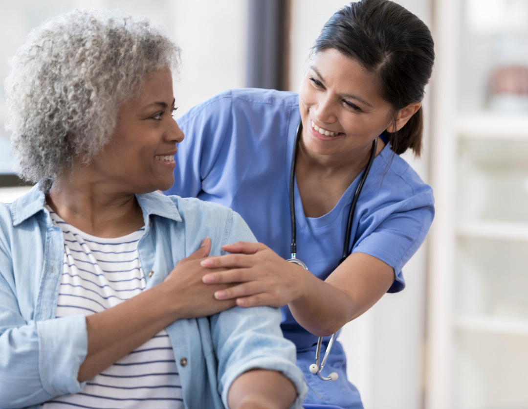 A healthcare worker touching hands with a female patient