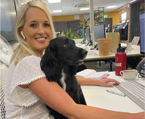 Employee, Debbie Holden, with a dog sat on her lap