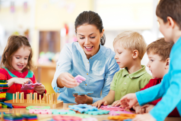 A teaching professional sat with young children