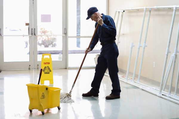 A school caretaker mopping the floor