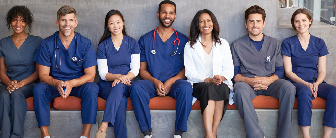 A group of healthcare professionals sat in a row smiling