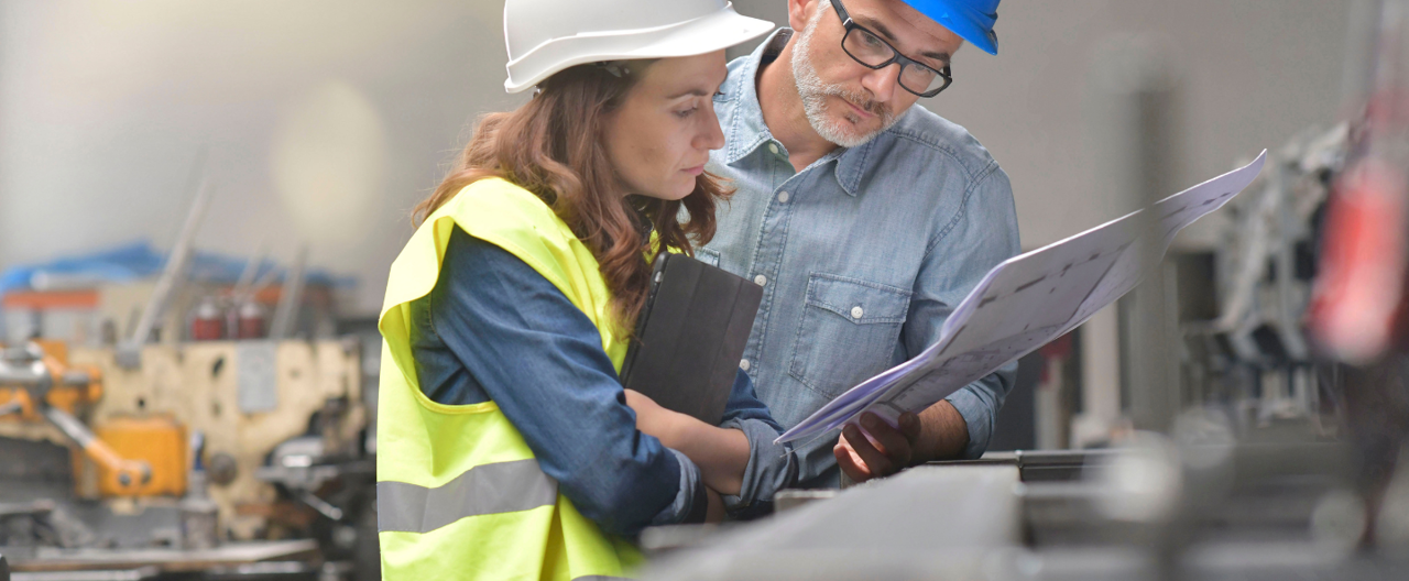 A male and female construction worker reading instructions