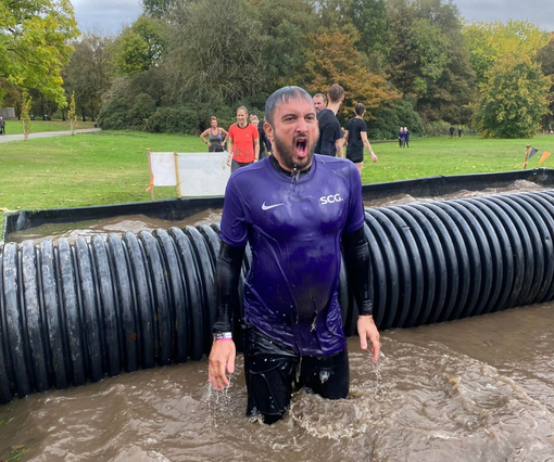 A male Spencer Clarke Group employee completing Tough Mudder obstacle