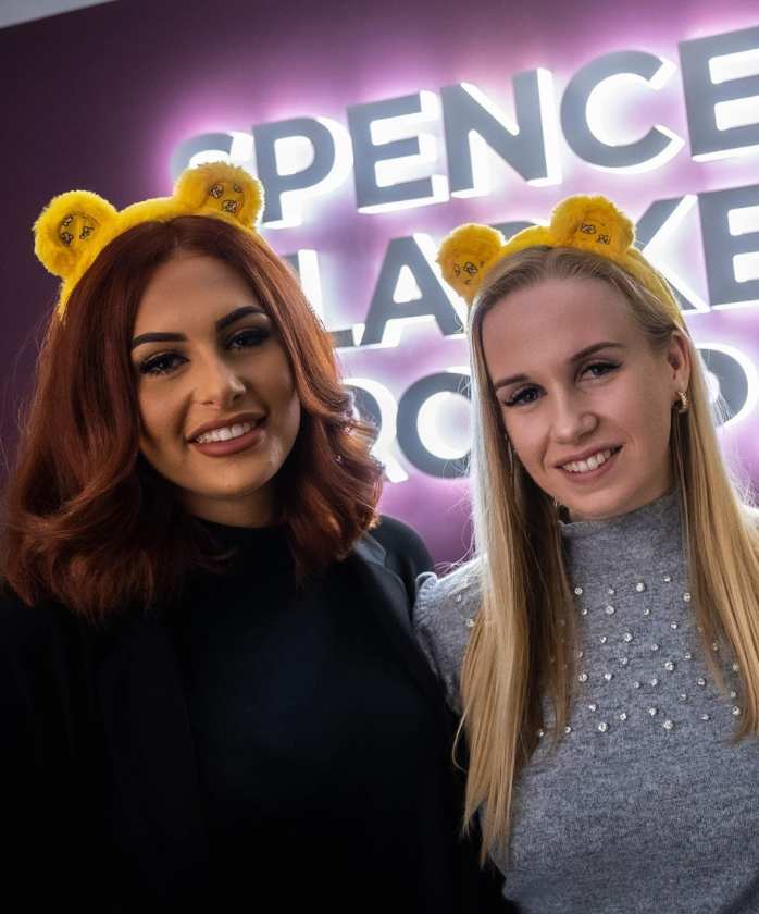  Two female Spencer Clarke Group employees wearing yellow teddy ears for Children in Need